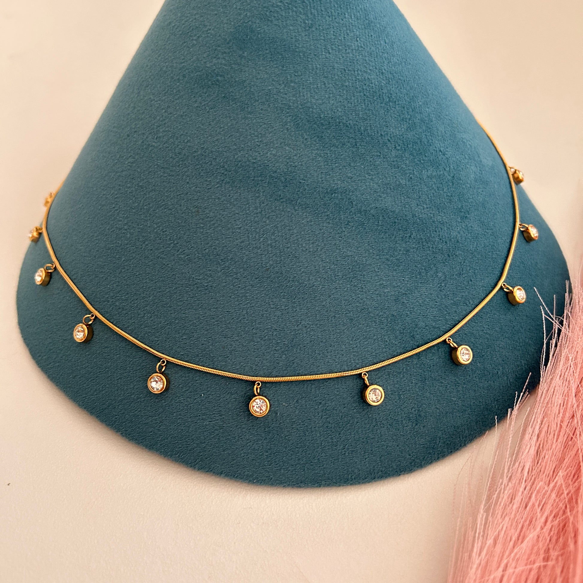 Elegant gold waist band with crystal drop charms on mannequin display.