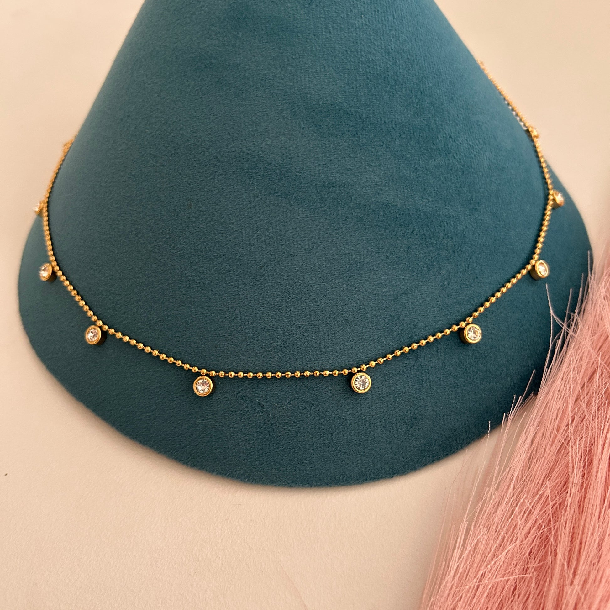 Gold beaded waist band with small crystal drop charms hanging along the chain.