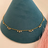 Close-up gold waist band with circular crystal drop pendants evenly spaced.