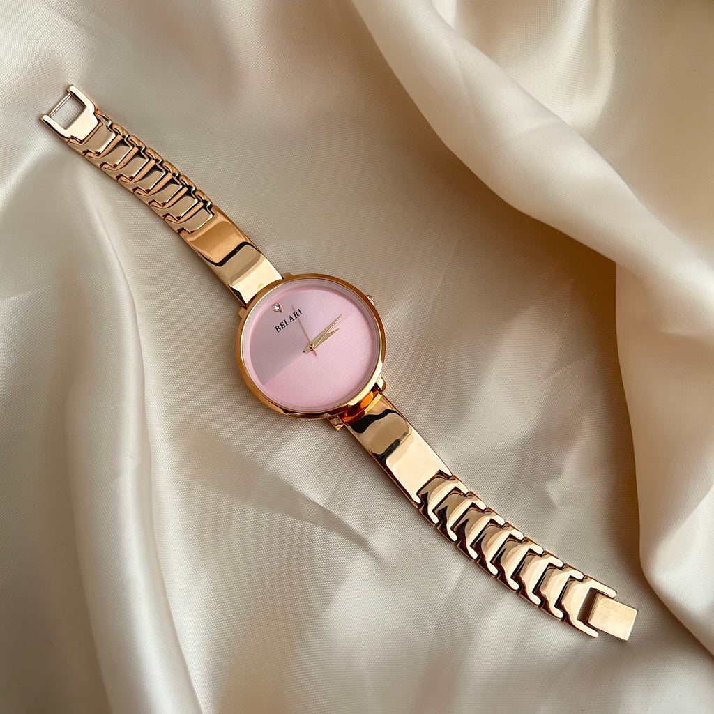Rose gold wristwatch with round dial placed on satin fabric background.