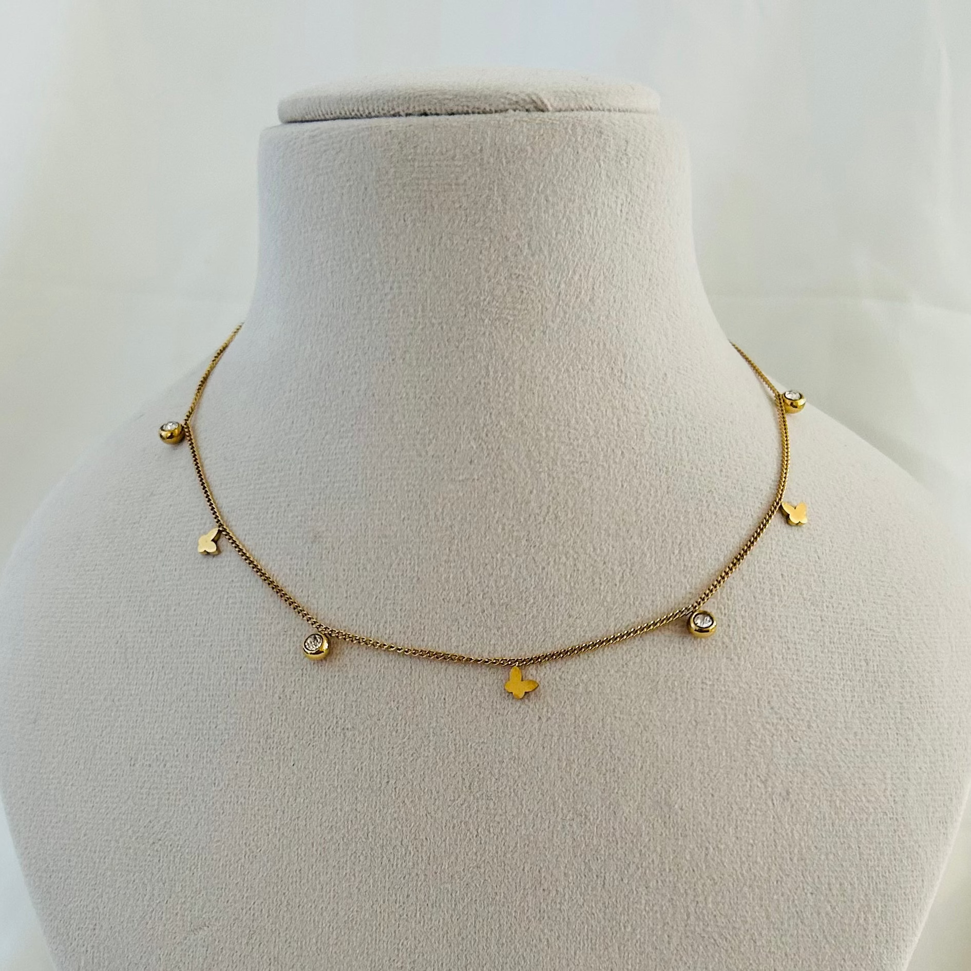Cute gold necklace with butterfly charms and crystals.