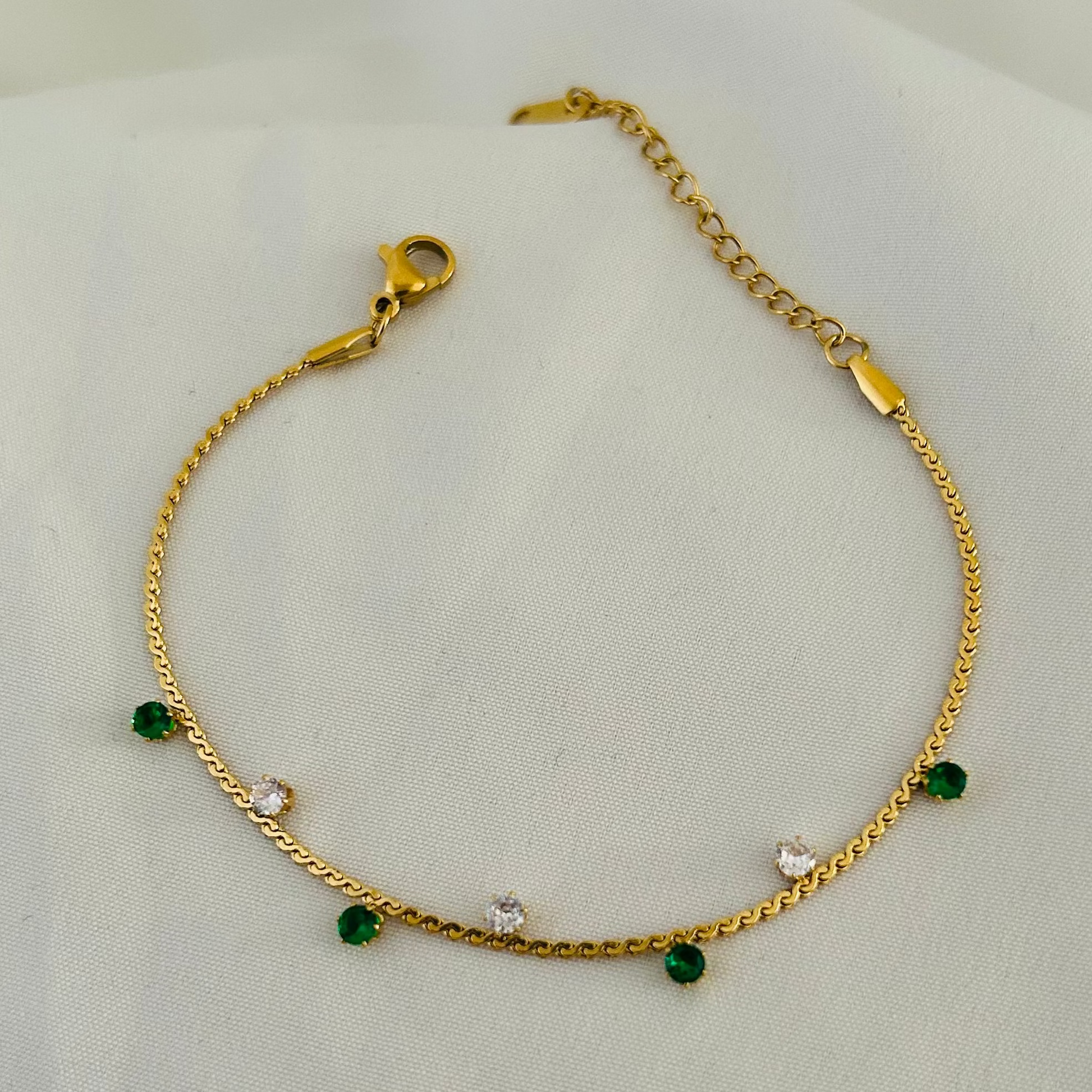 Gold bracelet with green beads and white stones