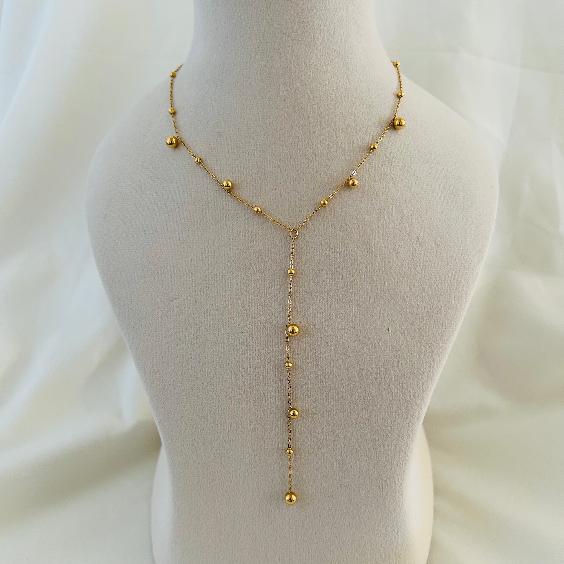 Elegant Y-style gold necklace with hanging bead chain.